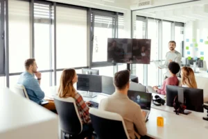 Professional software development team collaborating during a project meeting, discussing web development, coding, and digital solutions in a modern office